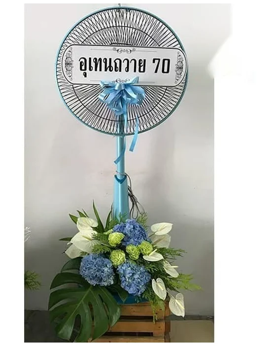 พัดลมเสาฟ้าผูกโบว์ฟ้าใต้ป้าย ช่อฐานไฮเดรนเยียฟ้า เบญจมาศเขียวลูกกลม หน้าวัวขาว ใบมอนสเตอรา